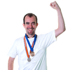 a person with two medals around their neck and making a fist above their head