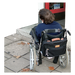 A person in a wheelchair facing a step into an entrance of a building
